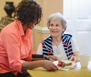 Caregiver serving client sandwich